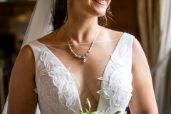 A portrait of a bride, wearing natural makeup and a modern dress holding her bouquet.