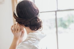 A bride wearing a soft low bun for her wedding at Cressing Temple Barns.