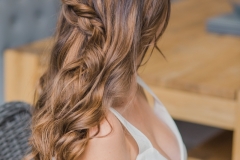 A bride wearing her hair in soft waves with a chunky braid. 