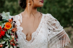A bride wearing a boho updo and a red lipstick for her wedding day. 